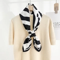 Chic black and white zebra pattern silk scarf paired with a beige knit top - Large / Black