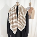 Elegant striped square silk scarf in beige and white draped over black attire - Large / Light Orange