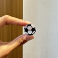 Dettaglio macro di un fermaglio per capelli a forma di calcio 3D con finitura perlata - Calcio