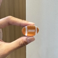 Nahaufnahme einer Mini-Haarklammer im Football-Design zur Darstellung der Größe - Rugbyball