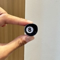 Detailansicht einer kleinen runden Billard 8 Ball Sport Haarklammer in den Fingern - Billard