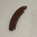 Detail view of brown velvet banana hair clip showing its plush flocking texture and teeth - Brown