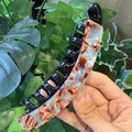 Detailed close-up of a tortoise shell banana clip with tortoise pattern and comb teeth - Amber Marble