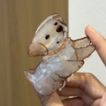 Detail of cream dog-shaped claw clip with pearlescent finish and brown line accents - Terrier Shape