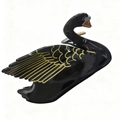 Dettaglio del fermaglio per capelli a cigno nero con ali dorate e finitura lucida - Nero