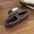 Deep coffee brown large glossy hair claw clip with geometric hollow design on wood surface - Coffee