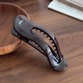 Pince à cheveux évidée bordeaux profond avec finition brillante sur bureau en bois - Café