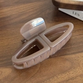 Pince à cheveux minimaliste rose lotus avec design géométrique sur surface en bois - Mocha