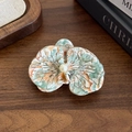 Elegant green marbled orchid hair clip with faux pearl on a dark wooden background - Rainbow