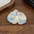 Elegante fermaglio per capelli a orchidea perlata con perla su fondo in legno scuro - bianco cangiante