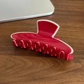 Pinza per capelli grande bordeaux e crema su tavolo in legno scuro - Rosso Bordo Bianco Molletta