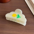 Pearly cream tulip claw clip with floral relief on dark wooden surface for hair styling - Yellow