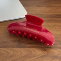 Pinza per capelli rosso scuro con testo dorato Hot Girls Go To Pilates su un tavolo - Clip a Artiglio Rossa