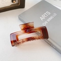 Detail of a square amber tortoiseshell hair claw clip with a strong metal spring and teeth - PC Dark Amber