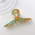 Acetate hair claw clip with orange and green marble pattern on light grey background - Amber Green