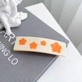 Pince à cheveux rectangulaire crème avec motifs de fleurs orange sur un livre - Barrette Étoile Jaune