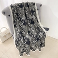 Elegant black cotton linen scarf with white paisley print draped on a chair - Black (LM394-4)
