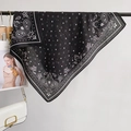 Black square scarf with white paisley and star print, elegantly draped as a fashion accessory - Square Style / Black