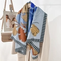 Fashionable floral print scarf with blue and yellow patterns draped over an overcoat - Blue