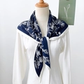 Detalle del pañuelo triangular azul marino con flores y bordes blancos en tejido seda - Azul