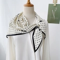 Elegante pañuelo de seda blanco y negro con lunares y flores sobre camisa blanca - Blanco