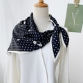 Elegante pañuelo de seda negro con lunares blancos y estampado floral en un maniquí - Negro