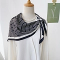 Fashionable black and white geometric striped silk scarf styled with pearls and white shirt - Black