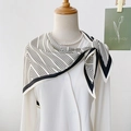 Elegant black and white geometric silk scarf tied on a mannequin with a pearl necklace - White
