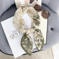 Elegante zijden sjaal met gouden bloemenprint en groene rand op een modetijdschrift - Groene Rand