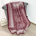 Lichte bordeauxrode en beige katoen-linnen sjaal met paisley-patroon op grijze fauteuil - Rode Rand