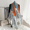 Detail van een dunne zijden sjaal met blauwe paisley patronen op een grijze bank - Beige Rand