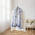Dettaglio di un foulard di seta leggero con motivi floreali blu su un top bianco chic - Floreale Astratto Blu