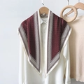 Detalle de un pañuelo de seda granate con lunares sobre una camisa blanca y percha de madera - Rojo