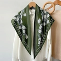 Elegante sciarpa in seta verde scuro con motivi floreali bianchi drappeggiata sulla camicia - Verde