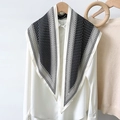 Pañuelo de seda con lunares y bordes negros sobre camisa blanca con percha de madera - Borde Blanco