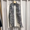 Polka dot long silk scarf in black and white hanging over a white long-sleeve shirt - Camellia Black