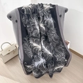 Écharpe longue élégante en noir avec motifs plumes blancs et texture soyeuse - Grand / Noir