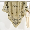 Olive paisley print square bandana scarf hanging against a minimalist white background - Green