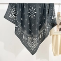 Large dark gray paisley square scarf with white bohemian patterns hanging on a rack - Black