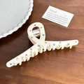Detalle macro de pinza de pelo de acetato blanco con pedrería de colores y resorte metálico - Pinza de Cinta (12.8cm)