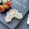 Elegante pinza per capelli a fiore in acetato avorio con petali traforati e strass - Beige