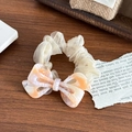 Creamfarbenes Organza-Haargummi mit einer orange-weißen Marmor-Acryl-Schleife - Blumiges Orange
