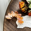 Molla per capelli ondulata in acetato perlato con sfumatura arancione su tavolo in legno - Arancio Iridescente (8.8cm)