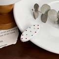 Pasador de pelo ovalado blanco con pedrería multicolor sobre un plato de cerámica blanco - Blanco