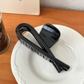 Glossy black hair claw clip with cross knot design on elegant white ceramic plate - Glossy Black-12cm