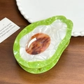 Elegant avocado-shaped hair claw clip with green pearlescent finish on wooden desk - 10.3cm