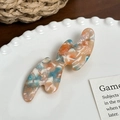 Eleganter gewellter Haarclip aus Acetat mit buntem Marmormuster auf Vintage-Hintergrund - Blau Orange