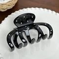 Polished black and white polka dot hair claw clip with octopus claw design on a plate - Pumpkin Clip / Black