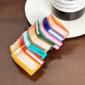 Colorful book stack hair claw clip with pearlescent finish on dark wood background - Orange Book Stack Claw