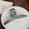 Polished silver metal hair claw clip with cross-spiral design on white plate - Straight Hair Clip - 12.5cm